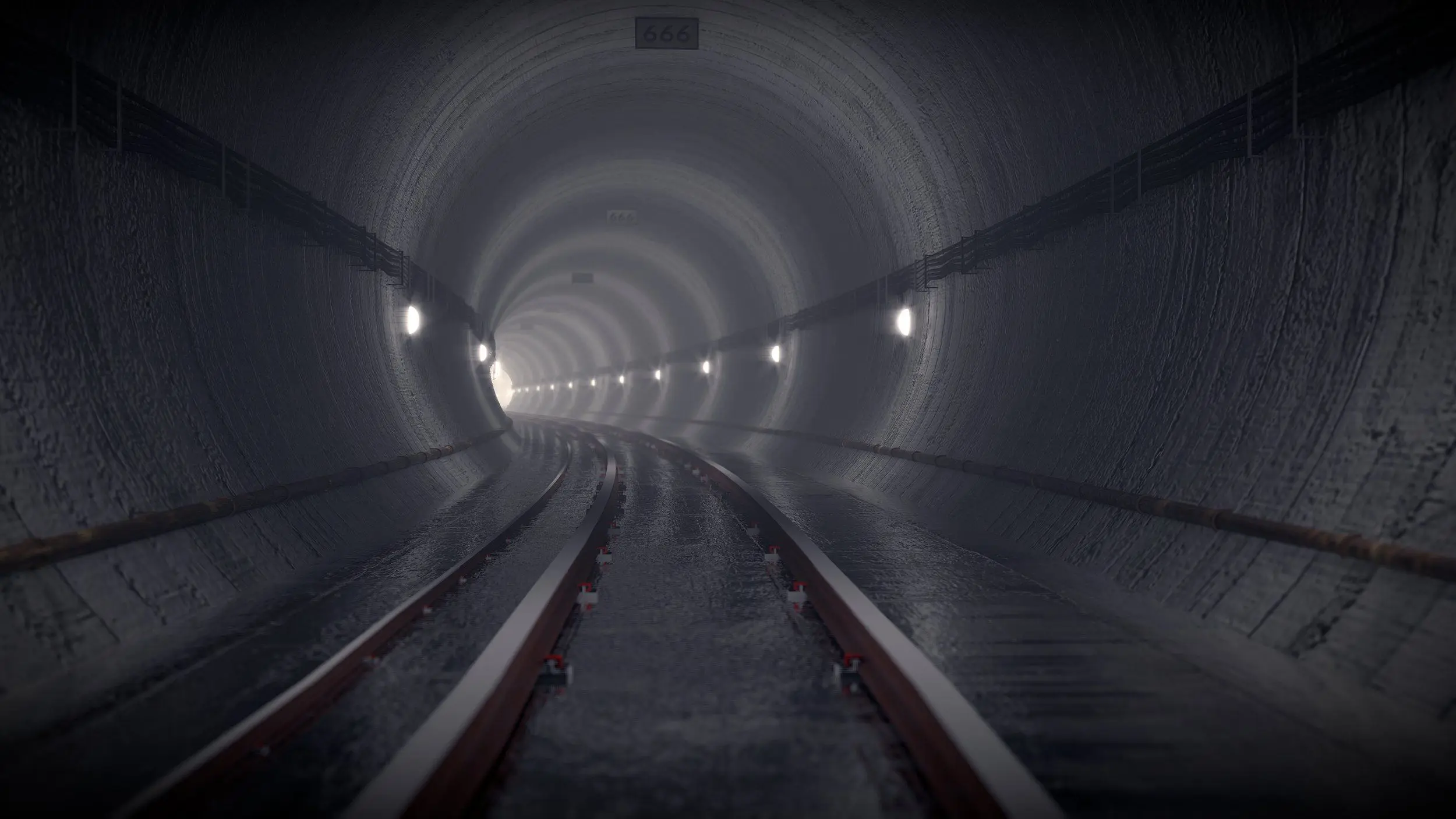 Train tracks in a dark, damp subway tunnel go on, curving left into the distance.